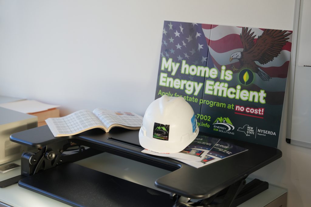 picture of the lap top and constructions helemt on the desk in the office